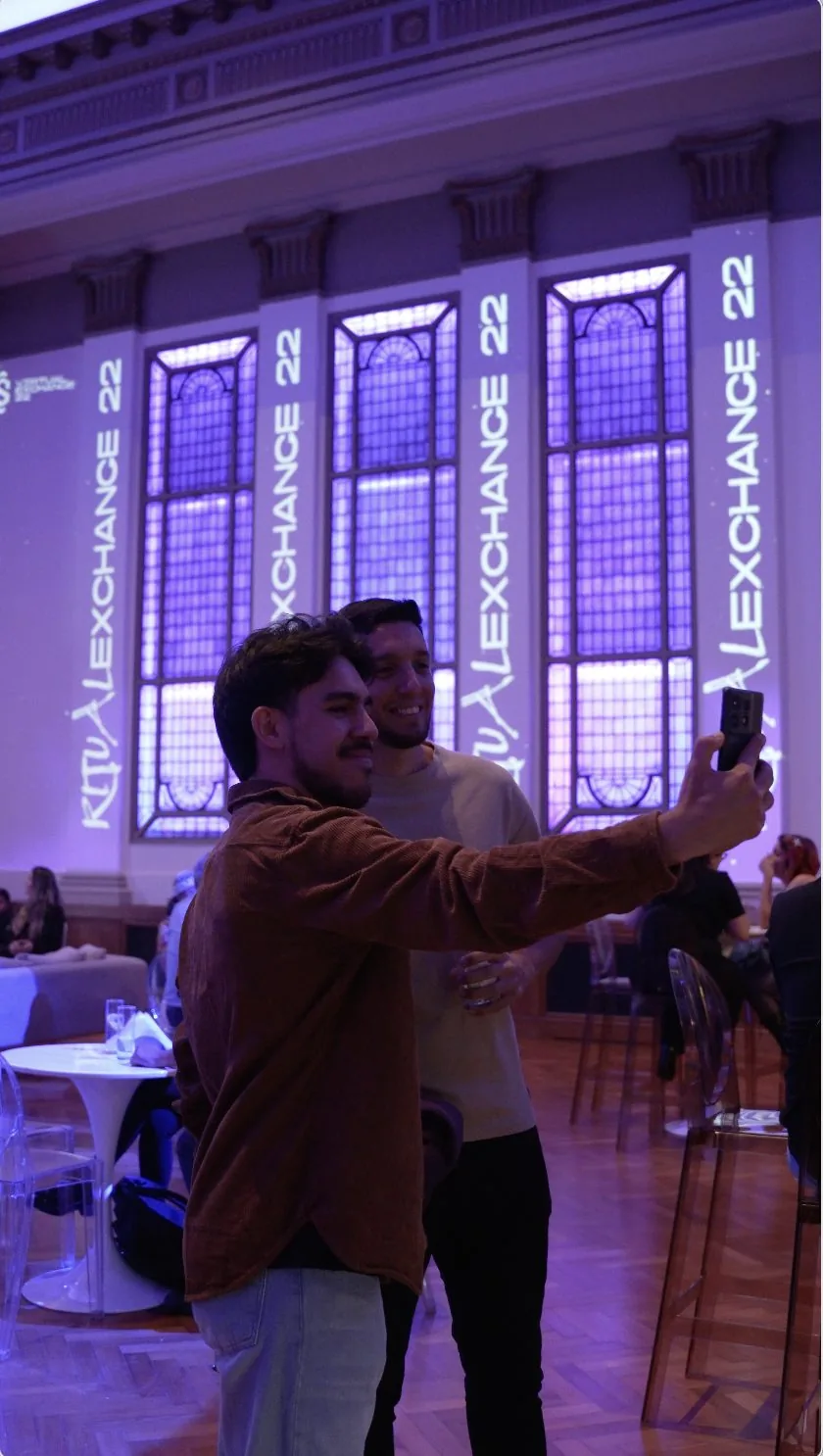 Clientes sacándose una selfie con la marca Ritual Exchange 22 proyectada en el salón
